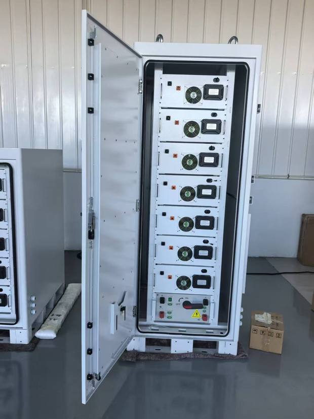 Open cabinet with seven battery modules and a DC isolator panel